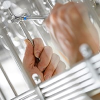 closeup of an engineer's hand fixing a leak in a fluid system