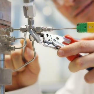 Ein Ingenieur verwendet Swagelok-Rohrverschraubungen bei einem Mikroreaktor