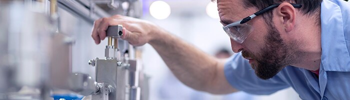 Man adjusting an industrial fluid system filter