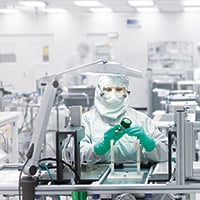 Empleado de ensamblaje fabricando semiconductores y componentes en una sala limpia Swagelok.