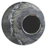 Photographie en gros plan montrant le phénomène de corrosion caverneuse sur un acier inoxydable
