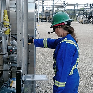 Stacey Phillips, directrice de l'ingénierie de terrain pour les Amériques chez Swagelok, utilise un casque de réalité augmentée pour effectuer, avec une équipe connectée à distance, une évaluation du matériel d’analyse dans une installation de traitement du gaz naturel. 