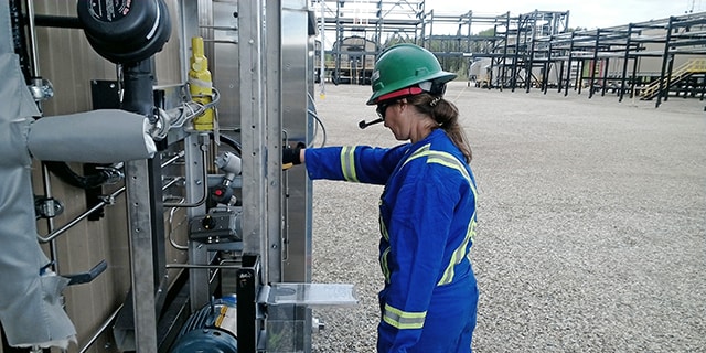 Stacey Phillips, Field Engineering Manager für die Region Amerika, nutzt ein Augmented-Reality-Headset, um die Analysegeräte in einer Gasaufbereitungsanlage in Kanada gemeinsam mit ihrem remote zugeschalteten Team zu prüfen. 