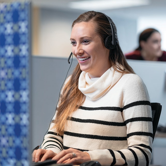 woman with headset typing on computer