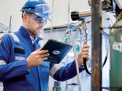 A Swagelok technician assessing industrial hoses, checking for wear, proper installation, and maintenance needs.
