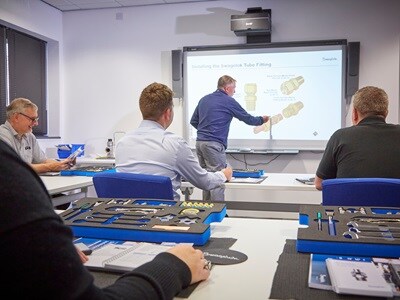 A Swagelok instructor leading a training session, educating professionals on fluid system components and best practices for installation.