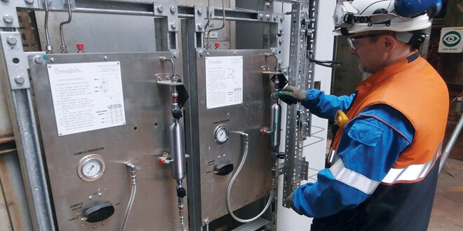 An operator using a grab sampling station