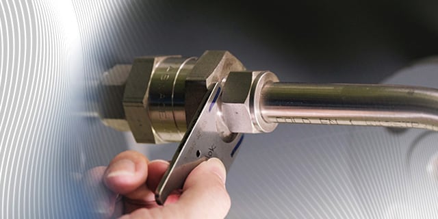 Hand doing a tube fitting installation and inspection 