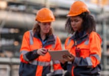 Two engineers in front of an oil and gas plant